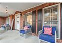Inviting covered front porch with cozy seating and stylish decor at 607 Crimsonwood Ct, Powder Springs, GA 30127
