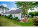 Beautifully landscaped backyard featuring mature trees, manicured lawn, and a charming white home exterior at 2752 Nautical Way, Villa Rica, GA 30180