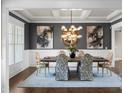Formal dining room featuring a coffered ceiling, stylish lighting, and sophisticated decor at 4800 Gablestone Xing, Hoschton, GA 30548