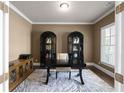 Cozy home office with ample natural light, a sleek desk, and elegant storage at 4800 Gablestone Xing, Hoschton, GA 30548