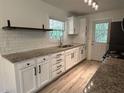 Bright kitchen featuring new white cabinets, granite countertops and subway tile backsplash at 779 Casplan Sw St, Atlanta, GA 30310