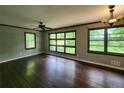 Bright living room with dark hardwood floors, large windows, ceiling fan, and decorative chandelier at 1321 Snapfinger Rd, Decatur, GA 30032