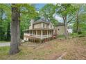 Traditional home showcasing a wrap-around porch and lush greenery at 2650 Wendell Creek Ln, Snellville, GA 30039