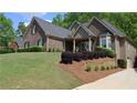 Beautiful home featuring a brick exterior with a well-manicured lawn and landscaping at 2656 White Rock Dr, Buford, GA 30519