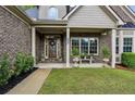 Inviting front porch of brick home featuring a bench and beautiful landscaping at 2656 White Rock Dr, Buford, GA 30519