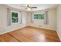 Cozy bedroom with a ceiling fan, hardwood floors, and natural light from two windows at 2911 Allegro Nw Dr, Atlanta, GA 30318