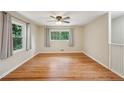 Bright bedroom featuring hardwood floors, a ceiling fan, and two large windows at 2911 Allegro Nw Dr, Atlanta, GA 30318