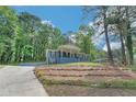 A charming blue brick home nestled amongst the trees, featuring a welcoming front porch and well-kept lawn at 3430 Shorelake Dr, Tucker, GA 30084