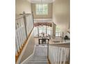 View of the staircase with carpet, white railings and a view of the dining room below at 5595 Timson Ln, Johns Creek, GA 30022