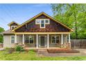 Charming home featuring a covered front porch with wooden porch swings, stone supports and a landscaped yard at 72 Griggs Sw St, Marietta, GA 30064