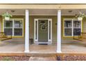 Inviting front porch with wooden porch swings, white columns, and a decorative front door with floral wreath at 72 Griggs Sw St, Marietta, GA 30064