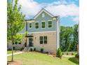 Charming townhome with a brick facade, manicured lawn, and inviting entrance with black door and awning at 1230 Ainsworth Aly # 34, Sugar Hill, GA 30518