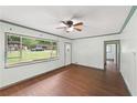 Bright living room featuring hardwood floors, a ceiling fan, and a large window for ample natural light at 2823 Connally Sw Dr, Atlanta, GA 30311