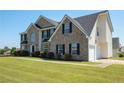 A two-story brick home with an attached garage sits on a lush green lawn at 9482 Deer Crossing Ln, Jonesboro, GA 30236