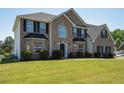 A charming two-story home with a well-kept lawn and manicured bushes at 9482 Deer Crossing Ln, Jonesboro, GA 30236