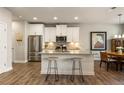 Modern kitchen features stainless steel appliances, white cabinetry, and an island with seating at 120 Maple Creek Way, Woodstock, GA 30188