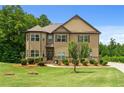 Charming two-story home featuring manicured lawn, detailed landscaping, and a circular driveway at 279 Sturry Dr, Mcdonough, GA 30252