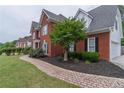 Beautiful brick home featuring manicured landscaping and a brick paver walkway at 1004 Spruce Creek Ln, Lawrenceville, GA 30045