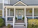 Charming front porch with potted plants, hanging flowers, welcome sign, and seating offers curb appeal at 4013 Dover Ave, Alpharetta, GA 30009