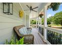 Cozy covered porch features a wicker sofa, ceiling fan, hanging plants, and a view of the landscaped front yard at 4013 Dover Ave, Alpharetta, GA 30009