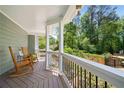 Relaxing covered porch with rocking chairs overlooks the lush, green backyard at 4013 Dover Ave, Alpharetta, GA 30009
