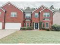 Two-story brick home with a well-kept lawn, showcasing traditional architecture and curb appeal at 5584 Dendy Trce, Fairburn, GA 30213