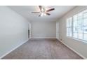 Carpeted living room with neutral walls, ceiling fan, and staircase at 8431 Magnolia Dr, Jonesboro, GA 30238