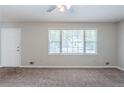 Bright living room featuring neutral walls, plush carpet, and a large window for ample natural light at 8431 Magnolia Dr, Jonesboro, GA 30238
