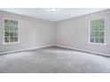 Cozy bedroom with neutral carpet, light gray walls, two windows, and plenty of natural light at 4872 Lewis Rd, Powder Springs, GA 30127