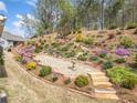 Scenic backyard featuring a terraced garden with stone steps and colorful plantings at 221 Hickory Bluffs Pkwy, Canton, GA 30114