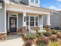 Inviting front porch with stone accents, rocking chairs, and meticulously landscaped garden at 221 Hickory Bluffs Pkwy, Canton, GA 30114