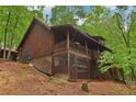 Log cabin exterior featuring a covered porch and natural landscaping at 2361 Mann Rd, Douglasville, GA 30134