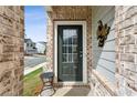 Home's inviting front door with sidelight, brick wall, and siding detail, and a decorative item on the house at 4389 Treadle Sw Rd, Mableton, GA 30126