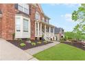 Well-manicured lawn and landscaping with view of the covered porch and brick home at 1342 Winborn Nw Cir, Kennesaw, GA 30152