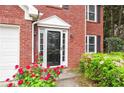 Elegant front door with decorative trim, framed by colorful landscaping and brick facade at 2727 Northgate Nw Way, Acworth, GA 30101