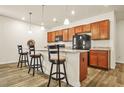Cozy eat-in kitchen with wooden cabinets, granite countertops, and bar stool seating at the breakfast bar at 9010 Jim Purcell Dr, Covington, GA 30014