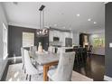Elegant dining room features modern lighting, open to the kitchen with barstool seating, perfect for entertaining at 404 Wade Creek Rd, Alpharetta, GA 30009