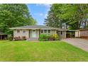 Charming single-story home with a well-manicured lawn, mature trees, and a quaint light-blue front door at 975 Shirley Se St, Smyrna, GA 30082