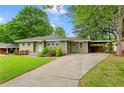 Charming single-story home with a well-manicured lawn, long driveway, and light-blue front doors at 975 Shirley Se St, Smyrna, GA 30082