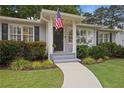 Close up of charming house, sidewalk, tidy landscaping, and a patriotic American flag at 1788 Beacon Hill Ne Blvd, Atlanta, GA 30329