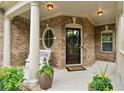 Welcoming front porch with brick accents, a charming bench, and a stylish front door at 280 Lakestone Pkwy, Woodstock, GA 30188