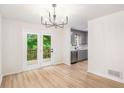 Dining area with light floors, chandelier, access to deck, open to updated kitchen at 450 High Creek Trce, Roswell, GA 30076