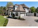 Beautiful home featuring a circular driveway, three-car garage, and manicured lawn at 1015 Bedford Gardens Dr, Alpharetta, GA 30022