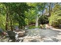 Inviting outdoor stone fire pit area with ample seating, perfect for cozy evenings and entertaining guests at 1015 Bedford Gardens Dr, Alpharetta, GA 30022