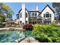 Gorgeous backyard featuring a sparkling pool, stone landscaping, and a private deck at 1015 Bedford Gardens Dr, Alpharetta, GA 30022