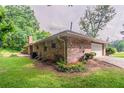 Brick home shows attached garage and a well-kept lawn with mature bushes at 2020 Buckingham Ct, Decatur, GA 30035