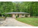 Cozy home with covered carport and a charming front yard, nestled in a serene, tree-filled setting at 446 Waterford Nw Rd, Atlanta, GA 30318