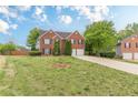 Spacious front yard view of a two-story brick home with a two-car garage and mature trees at 1316 Durham Ter, Mcdonough, GA 30252