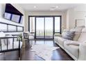 Cozy living room featuring dark hardwood floors, a TV, and a balcony with great views at 3475 Oak Valley Ne Rd # 2940, Atlanta, GA 30326