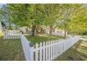 Well-maintained front yard featuring a white picket fence that enhances the property's curb appeal at 5045 Edinborough Pl, Sugar Hill, GA 30518
